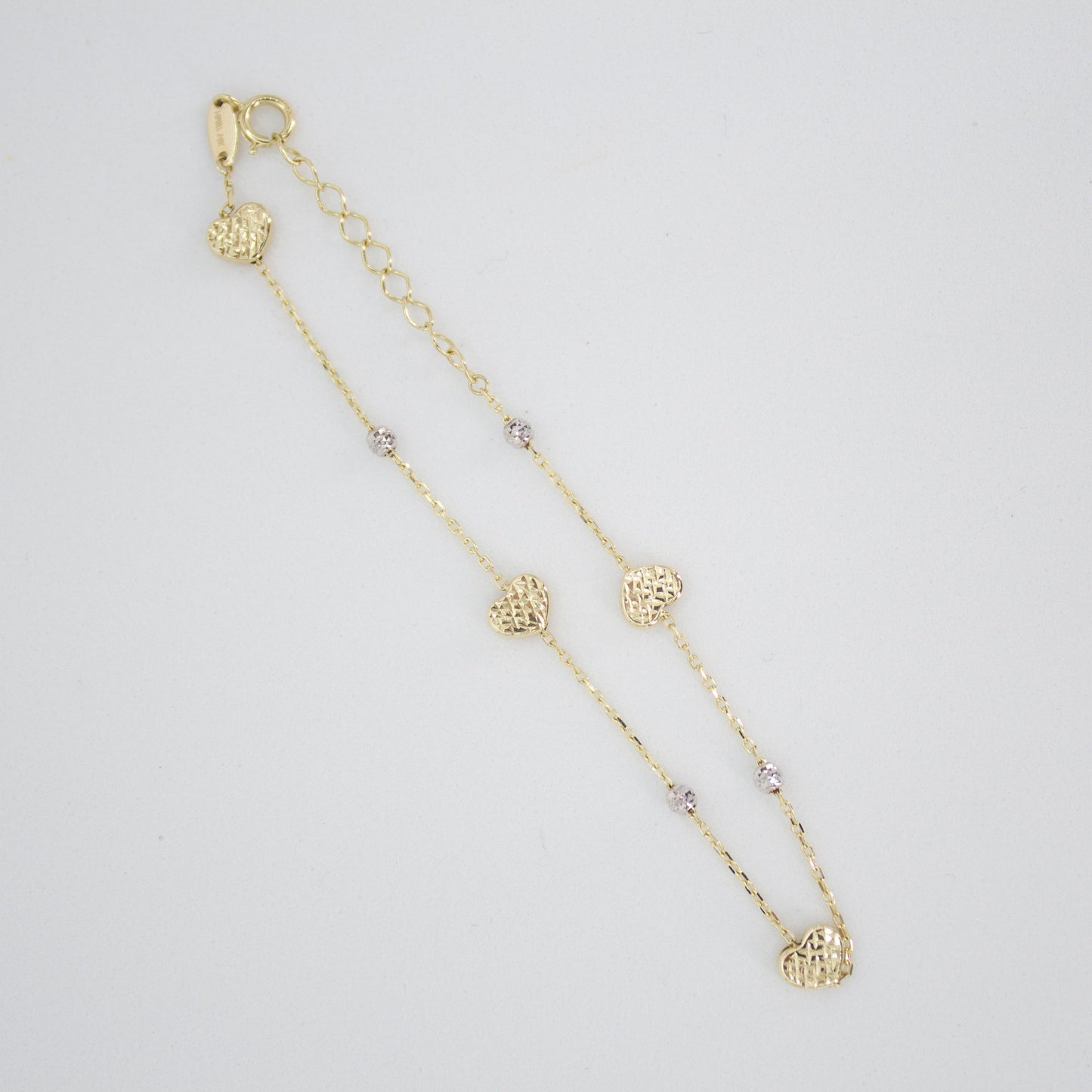 Pulsera corazones en oro combinado 14k.