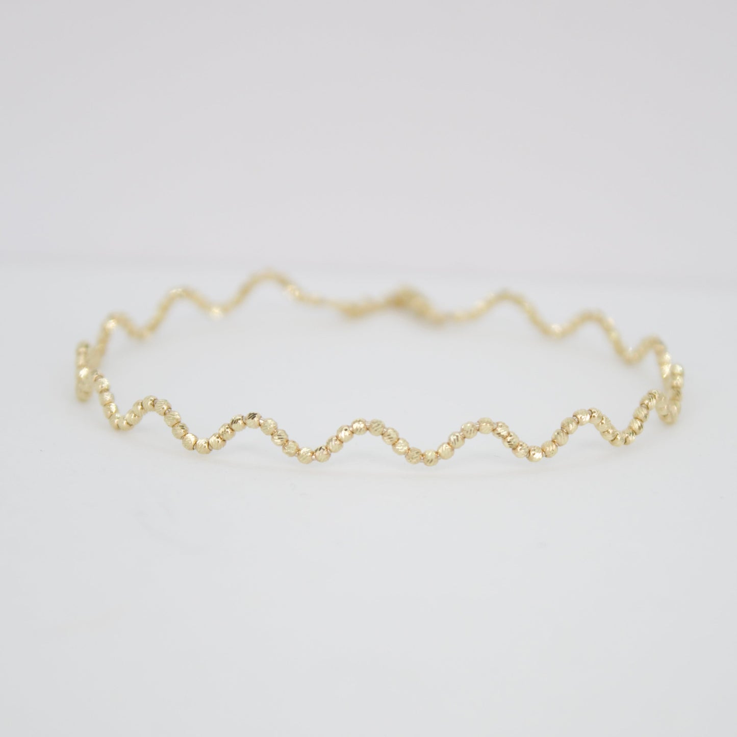 Pulsera rígida de bolitas en oro amarillo 14k.