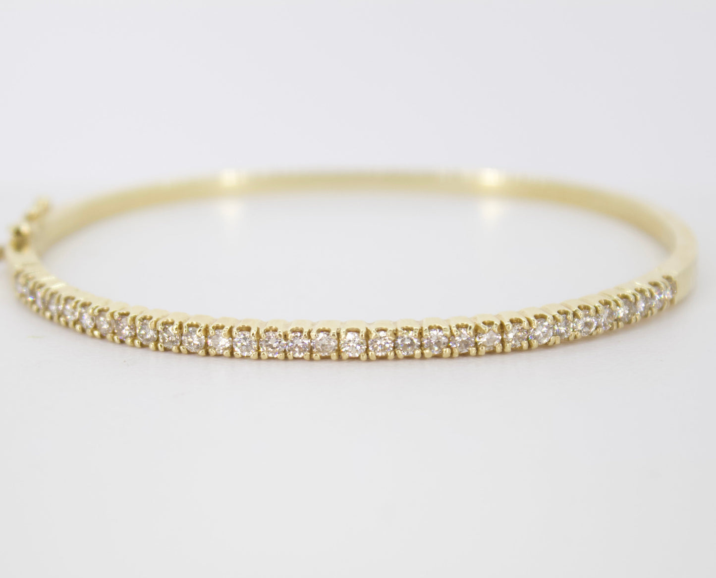 Brazalete rígido en oro amarillo 14k con diamantes.