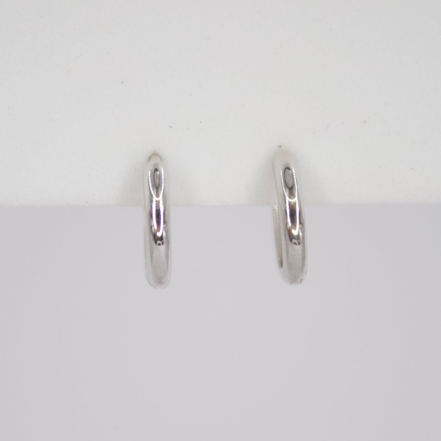 Aretes Huggies en oro blanco 14k.