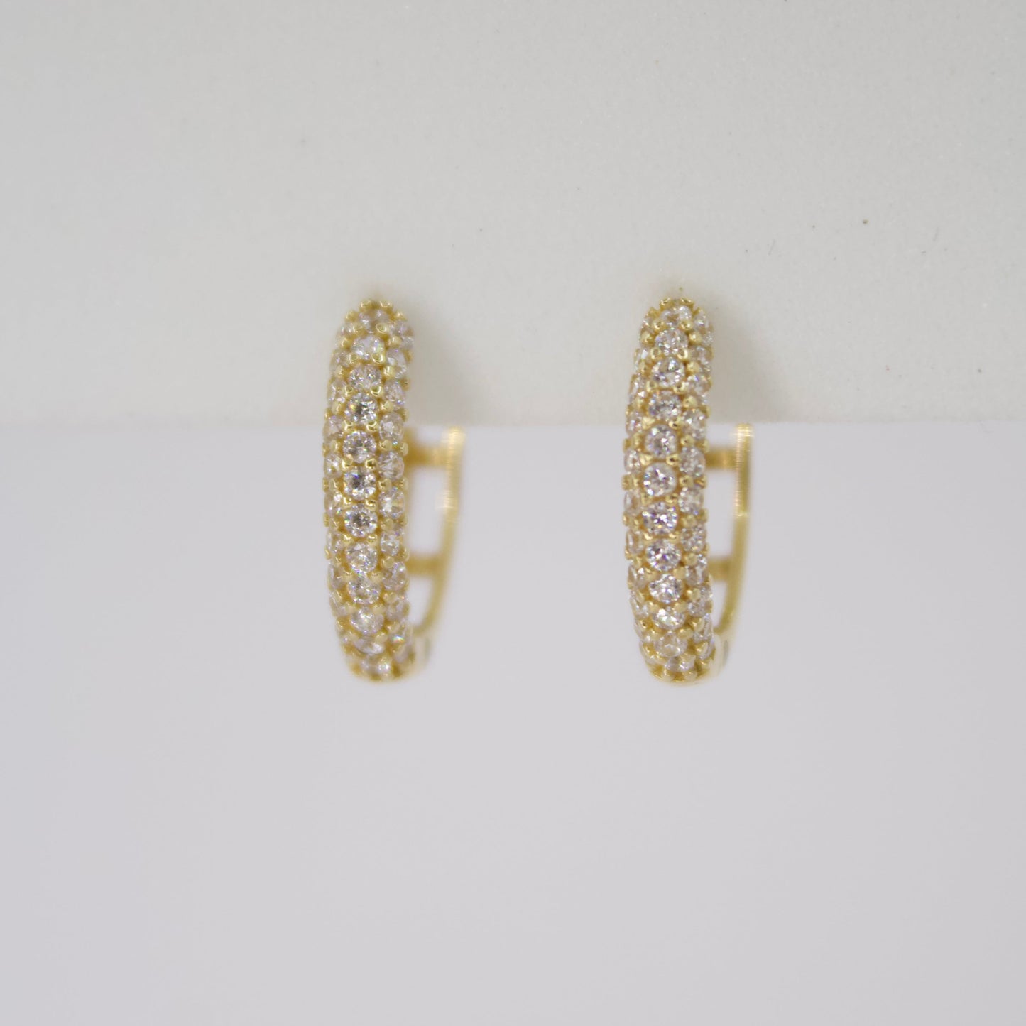 Aretes Huggies en oro amarillo 14k con zirconias.