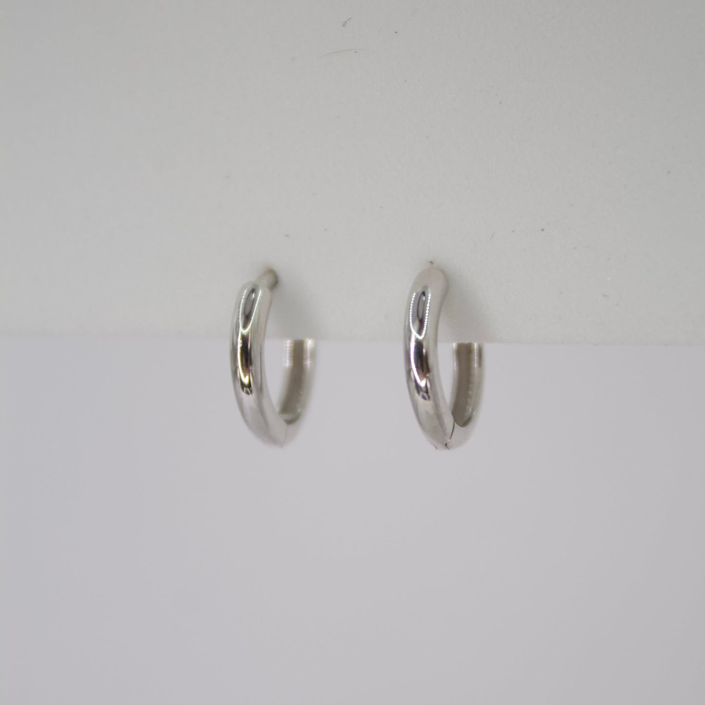 Aretes Huggies en oro blanco 14k.